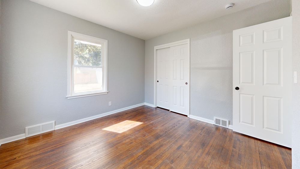 A post-war Charleswood bedroom with its original hardwood floor showing decades of wear.